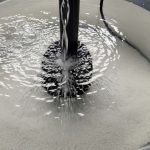 Aquarium salt mix dissolving in container with powerhead circulation for clear water