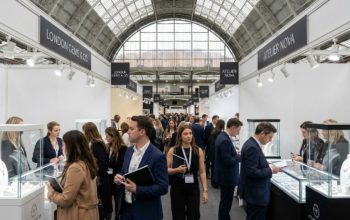 Trade buyers and jewellery designers browsing fine jewellery exhibitor stands at the Jewellery Show London 2026 inside the National Hall at Olympia