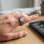 Close-up of a sleek fitness tracking ring worn on a person's finger.