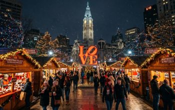 Christmas Village Philadelphia 2026 at LOVE Park with wooden vendor booths and holiday lights at night